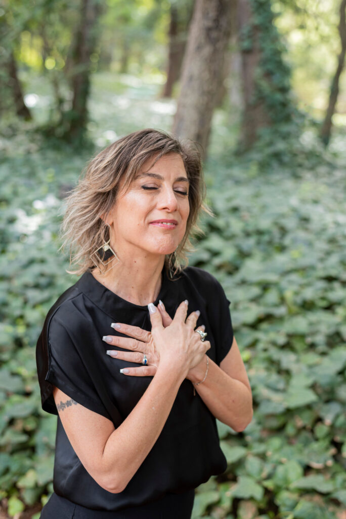 Melisa Corrales con la mano sobre el pecho, los ojos cerrados